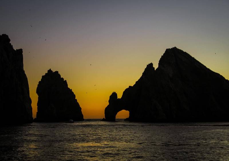 Couple watching Cabo San Lucas sunset from private catamaran